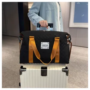 Vue détaillée d'un sac de voyage matelassé noir avec poignées dorées sur une valise