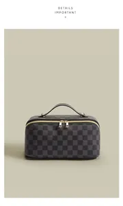 Detailansicht einer stilvollen schwarzen Kosmetiktasche mit Karomuster und Goldzipper