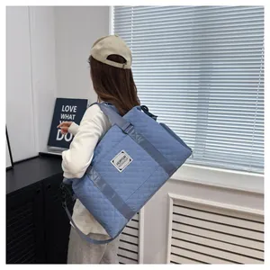 Sac de voyage matelassé bleu avec séparation humide-sec porté par un mannequin
