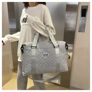 Vue détaillée d'un grand sac de voyage matelassé gris pour le fitness et les voyages.