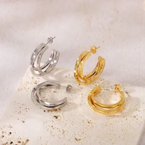 Détail des boucles d'oreilles créoles géométriques multicouches en or et en argent