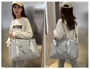 Deux vues d'un grand sac de voyage matelassé gris porté par un mannequin