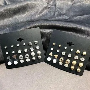 Close-up view showing a variety of simple geometric and rhinestone stud earrings