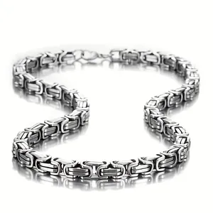 Détail d'un collier chaîne byzantine en acier inoxydable lourd avec fini argent poli