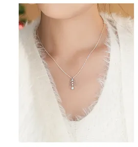 Close-up of a sterling silver Christmas tree pendant with zircons on a model.