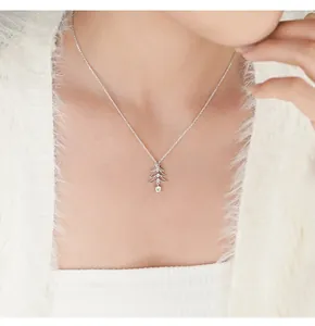 Close-up of a 925 sterling silver Christmas tree pendant necklace with zircons on model.