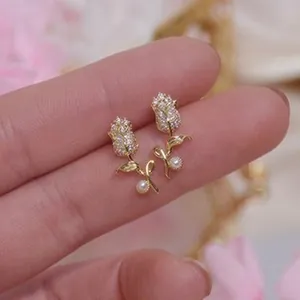 Elegant rose-shaped gold stud earrings with micro-inlaid crystals and pearl accents