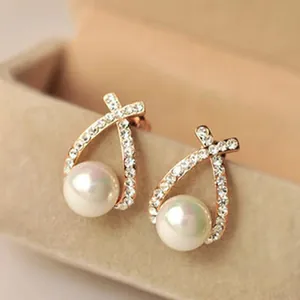 Detailed shot of elegant pearl stud earrings with sparkling rhinestone geometric design