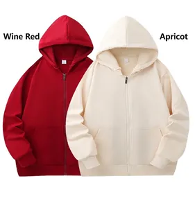 Detail view of oversized plain zip-up fleece hoodies in wine red and apricot tones