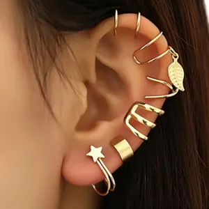 Close-up of stylish gold geometric ear cuffs and star stud on an Asian model's ear