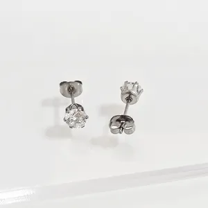 Close-up detail of silver-colored round rhinestone stud earrings with six-prong setting
