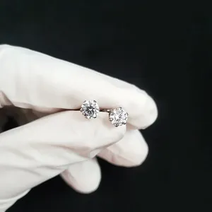 Detailed view of six-prong round brilliant rhinestone stud earrings on black background
