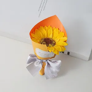 Detail view of a mini sunflower soap flower bouquet with orange wrap and ribbon bow