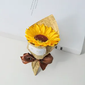 Close-up of a mini artificial sunflower bouquet wrapped in newspaper style paper