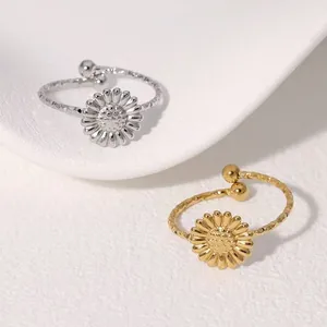 Detailed shot of silver and gold daisy open rings with adjustable textured bands.
