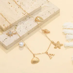 Detailed view of a gold ocean-themed necklace featuring shell, starfish, and pearl charms.