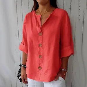 Détail d'une chemise en lin corail à col en V avec de grands boutons texturés.