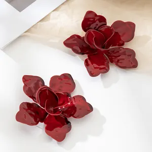 Detailed macro view of elegant deep red enamel flower stud earrings for women.