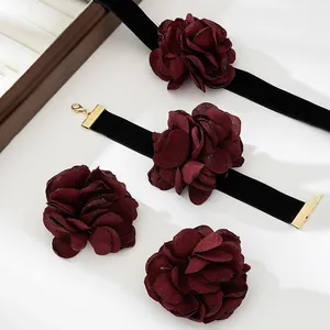 Detail of elegant deep red fabric flower chokers with premium black velvet ribbons