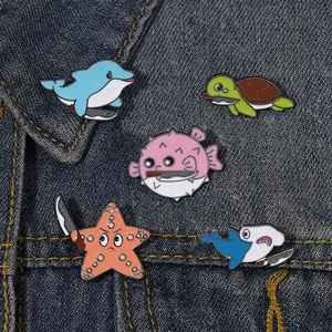 Set of cartoon marine animal enamel pins with funny knife designs on denim jacket