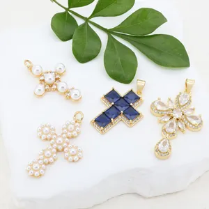 Vue détaillée de pendentifs en forme de croix avec zircons et perles dorées