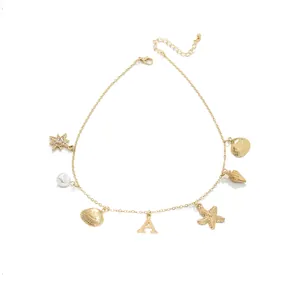 Gold ocean style necklace with pearl, shell, and initial A charms on white background.