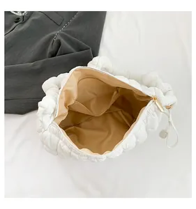 Interior view of white pleated puffy dumpling bag with internal pocket and lining