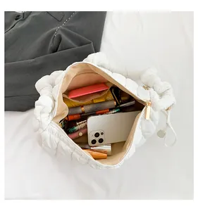 Close-up of white quilted handbag interior showing large capacity for phone and makeup.