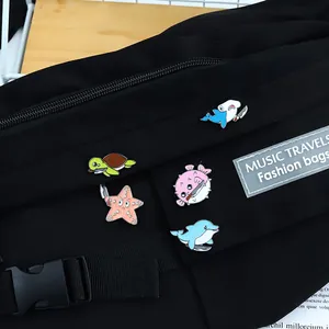 Close-up detail of funny cartoon sea animal enamel pins pinned on a black canvas bag