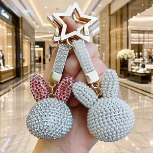 Dettaglio di portachiavi a forma di coniglio con cristalli e perle e chiusura a stella.