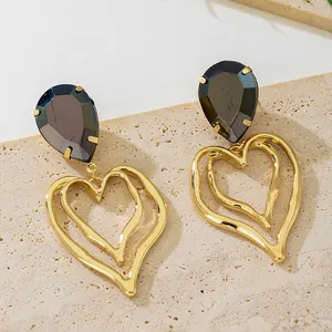 Detailed close-up of stylish golden double heart drop earrings with dark water drop crystals