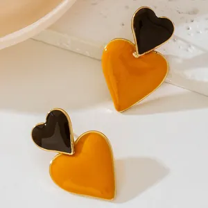 Detailed view of high-end yellow and black enamel heart-shaped double stud earrings