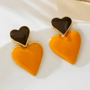 Detailed close-up of stylish double heart earrings with black and yellow enamel finish
