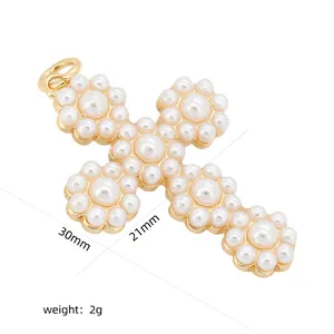 Détail d'un pendentif croix en perles plaqué or de 30 mm de hauteur