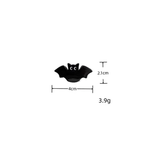 Macro detail view of small black bat acrylic hair claw clip for Halloween party hair styling
