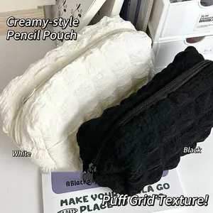 Detailed view of the puff quilted texture on white and black pencil cases