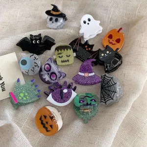 Detailed view of various glittery Halloween acrylic claw clips with ghost and pumpkin designs