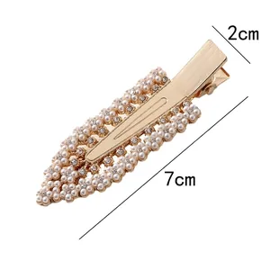 Détail de la pince à cheveux dorée avec perles et strass, longueur de 7 cm.