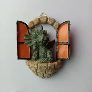 Detailed resin dragon figurine looking through an open stone window garden decoration.