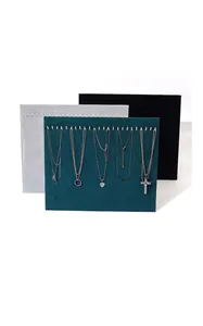 Detailed view of velvet jewelry display boards with necklaces on metal hooks.