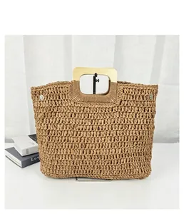 Detail of large straw woven tote bag featuring natural square wooden handles
