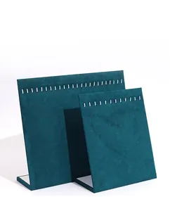 Detail of two dark teal velvet earring display stands with slots for jewelry organization