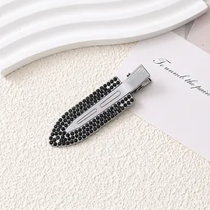 Vue détaillée d'une barrette en alliage argenté avec des strass noirs brillants