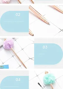 Close-up of a rose gold metal ballpoint pen with a fluffy pom-pom and a crown detail