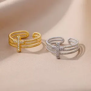 Detailed view of two gold and silver cross rings with pavé cubic zirconia stones.