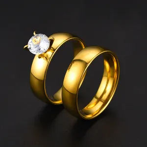 Detail view of gold-plated stainless steel couple's ring set with sparkling zircon stone.