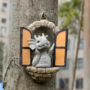 Close-up of a resin dragon figurine peering through an arched window on a tree.