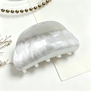 Detail view of white marble texture on a medium acrylic shark hair claw clip