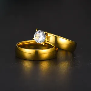 Macro view of a gold stainless steel couple ring set with a large sparkling zircon.