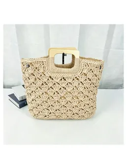 Beige hand-woven straw bag with square wooden handles and intricate shell pattern weave